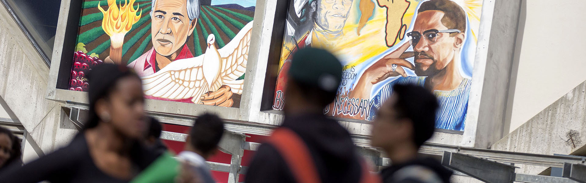 Students walk in front of the mural on Malcolm X Plaza 