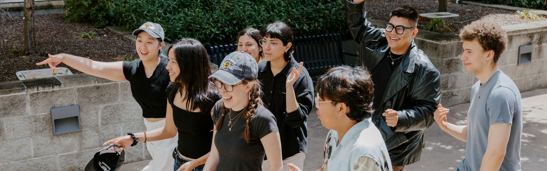 Group of students walking on campus talking and laughing together